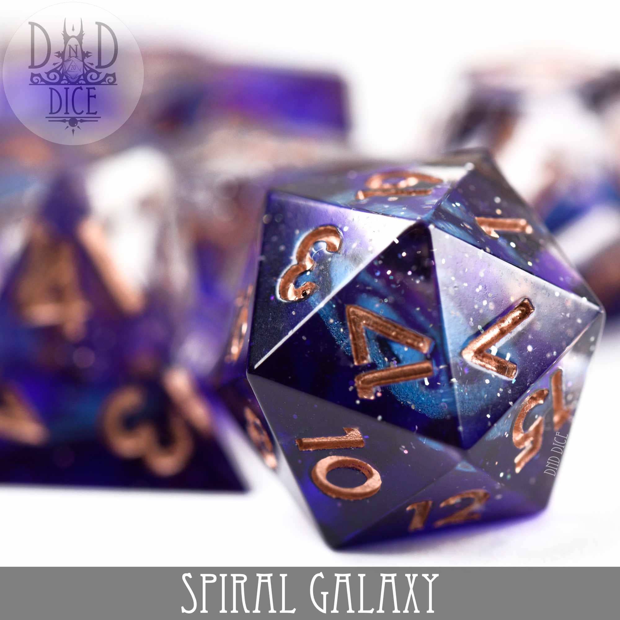 Spiral Galaxy Handmade dice in purple and gold resin.