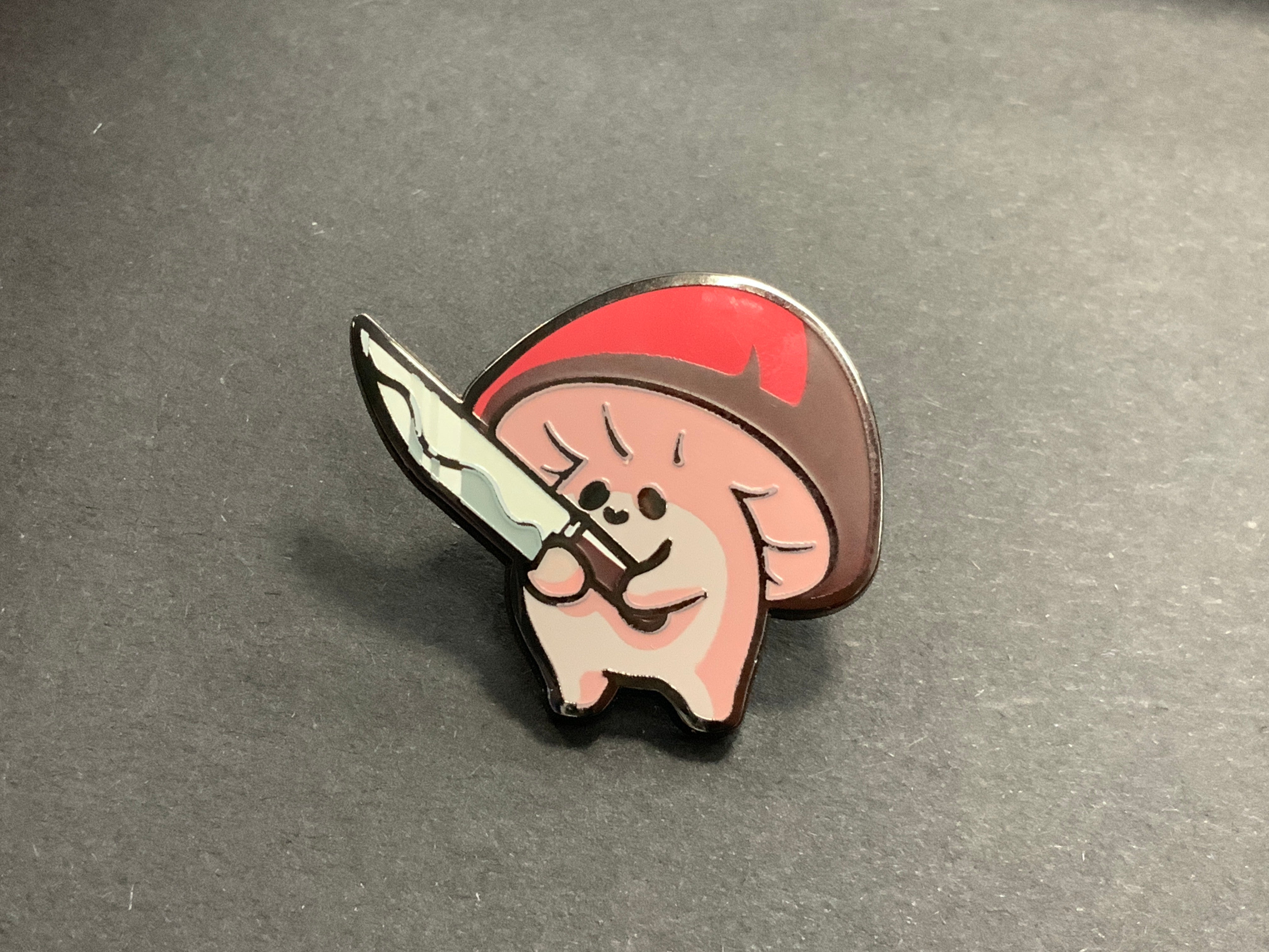 Heliana monster hunting pin with Hyphan, a cartoon mushroom warrior holding a sword.
