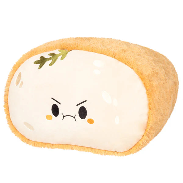 Sourdough Comfort Food Squishable Plushie shaped like bread with a grumpy face and a green sprig.