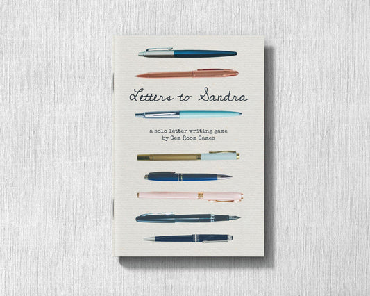 Letters to Sandra - A Solo Letter-Writing Game with pens shown on the cover.