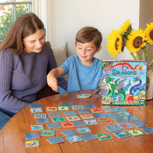 Dragons Shiny Memory & Matching Game being played by a woman and child at a table.