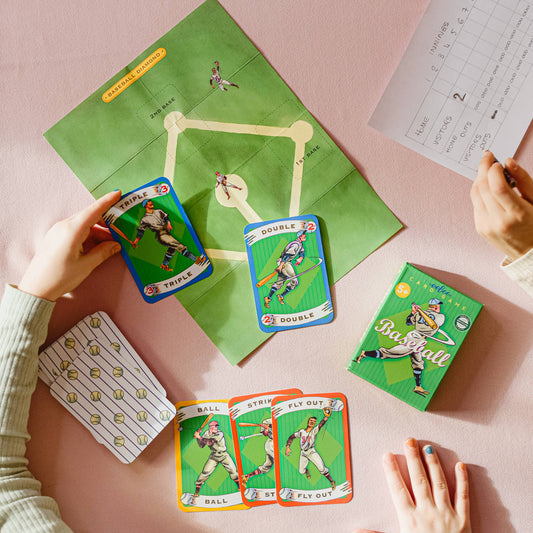 Baseball Playing Cards game set with score sheet and small baseball field board in use by two people at a table.