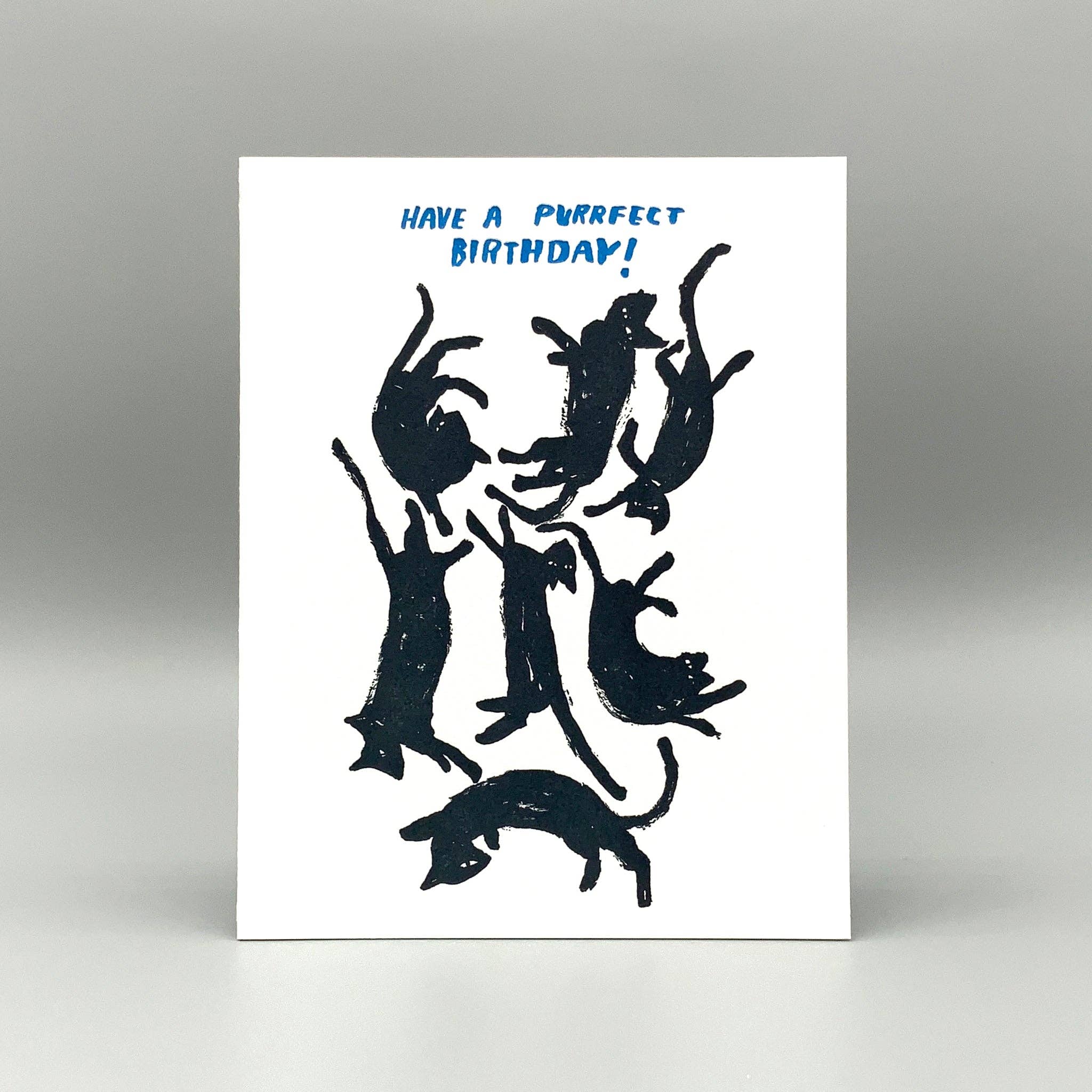 Purrfect Birthday card featuring black cat silhouettes, blue text on white, with recycled kraft envelope.
