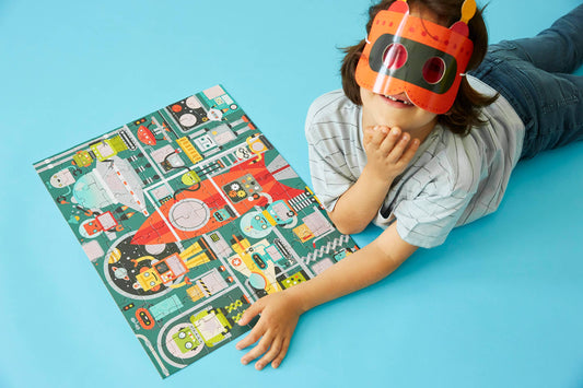 Robot Factory 100-Piece Decoder Puzzle with vehicles on blue floor, indicated by child in robot mask.