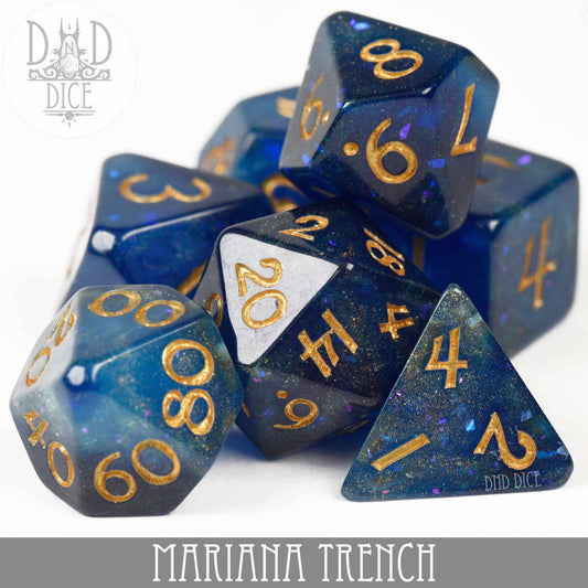 Mariana Trench 7-piece blue resin polyhedral dice set with gold numbers.