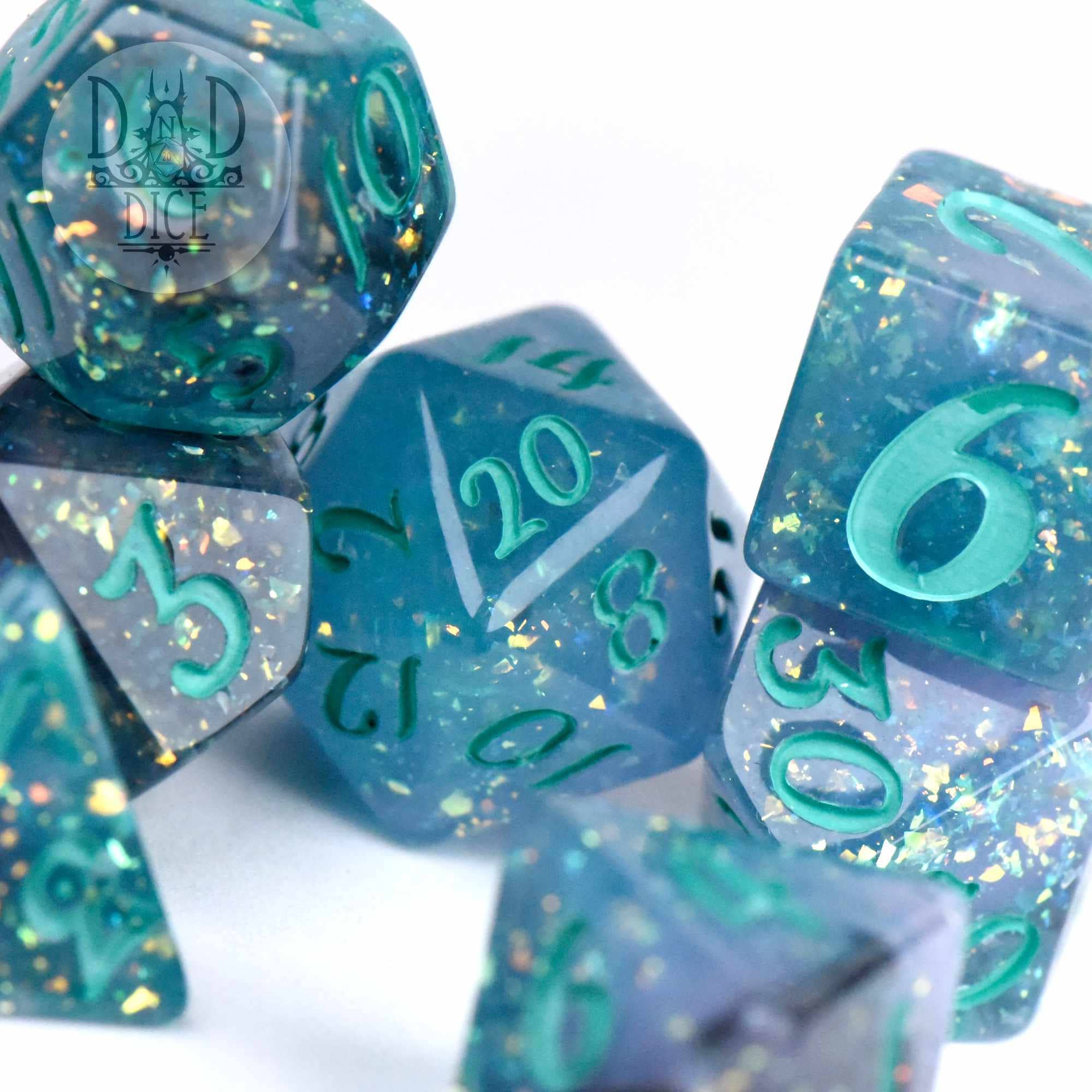 Translucent teal resin dice set with gold glitter and matching teal numbering.