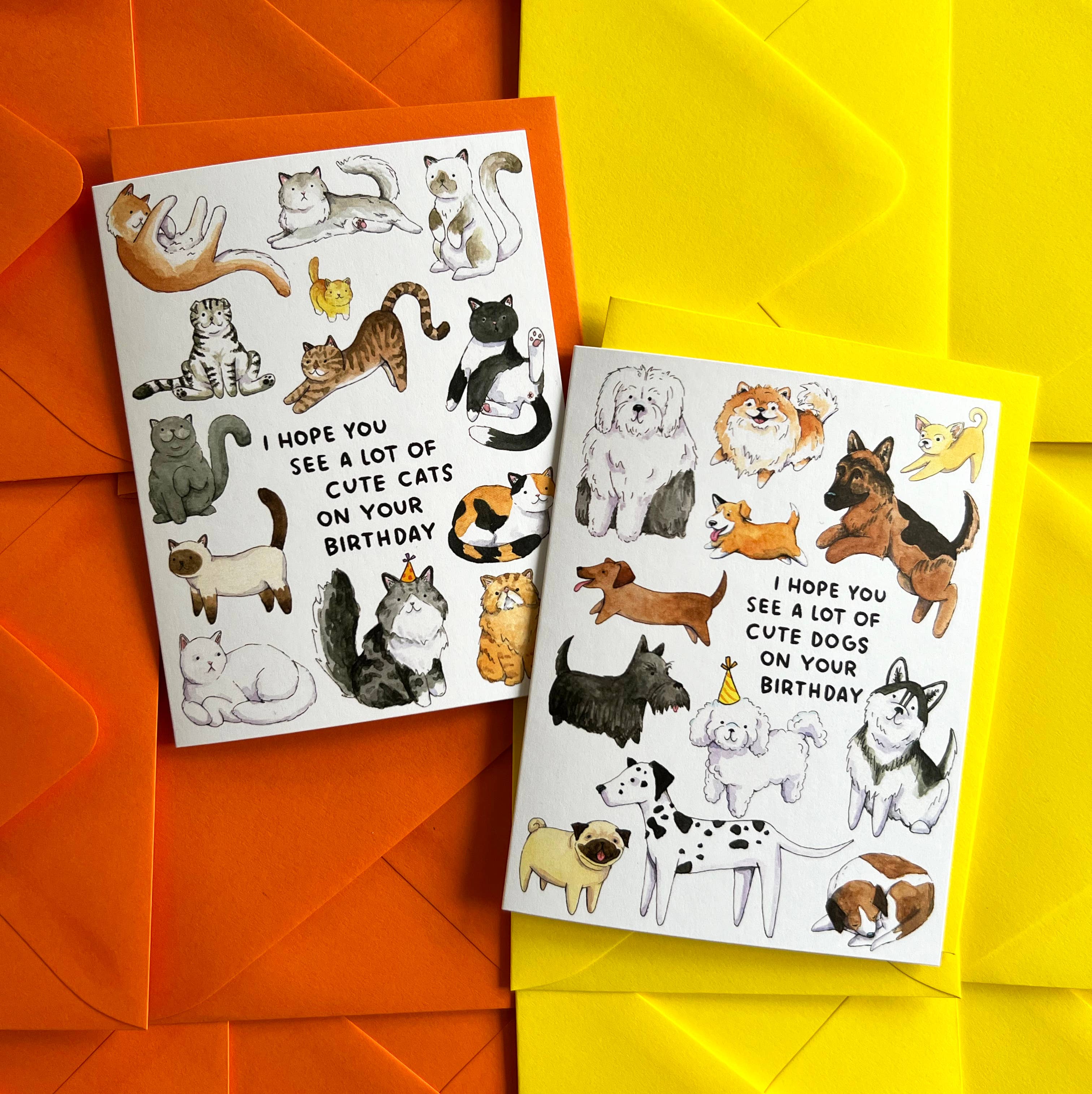 Two Hope You See A Lot Of Cute Cats birthday cards with watercolor cats, paired with orange and yellow envelopes.