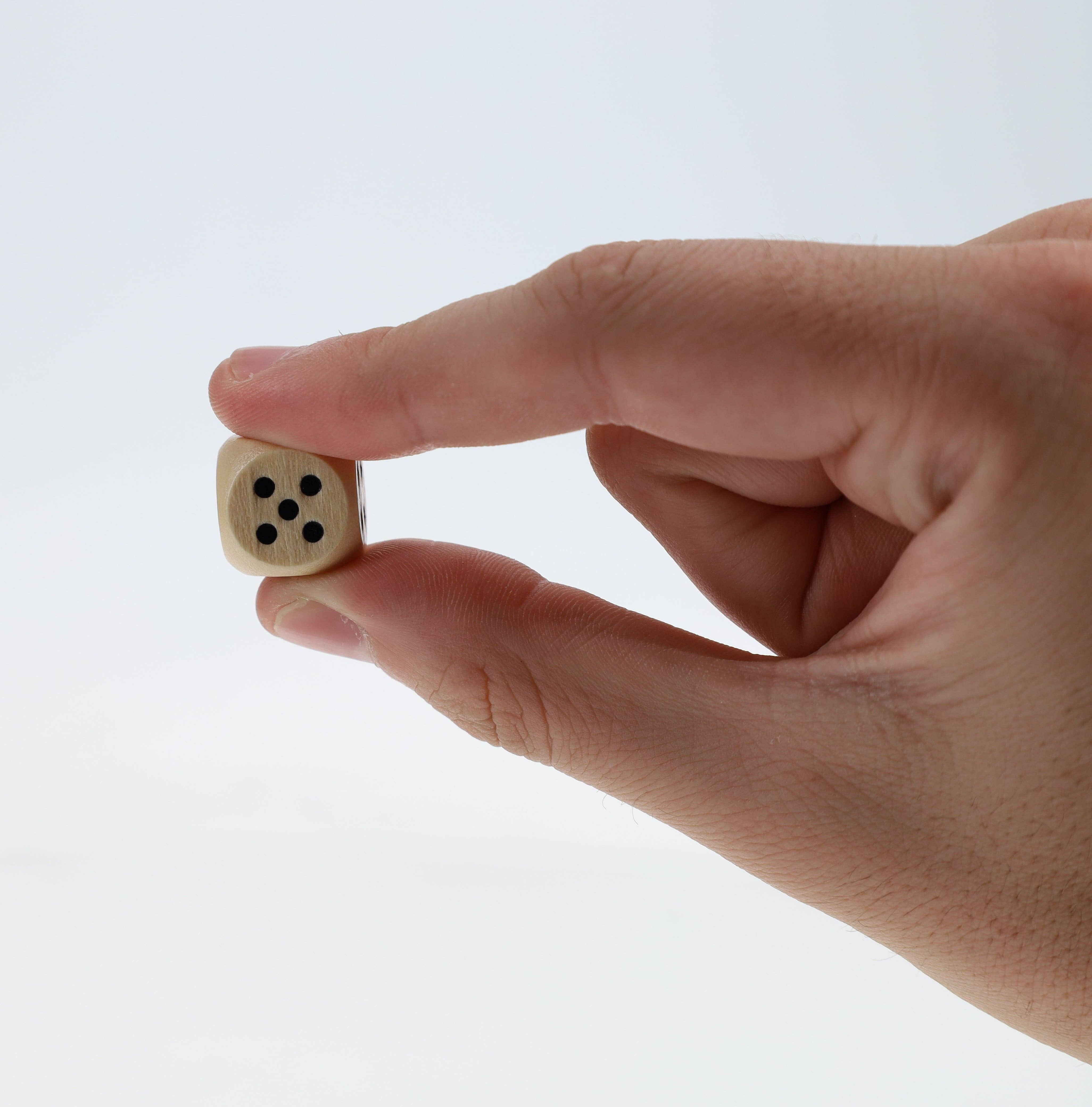 WE Games Cribbage and More Travel Game Pack with a wooden die showing five black dots held by a hand.