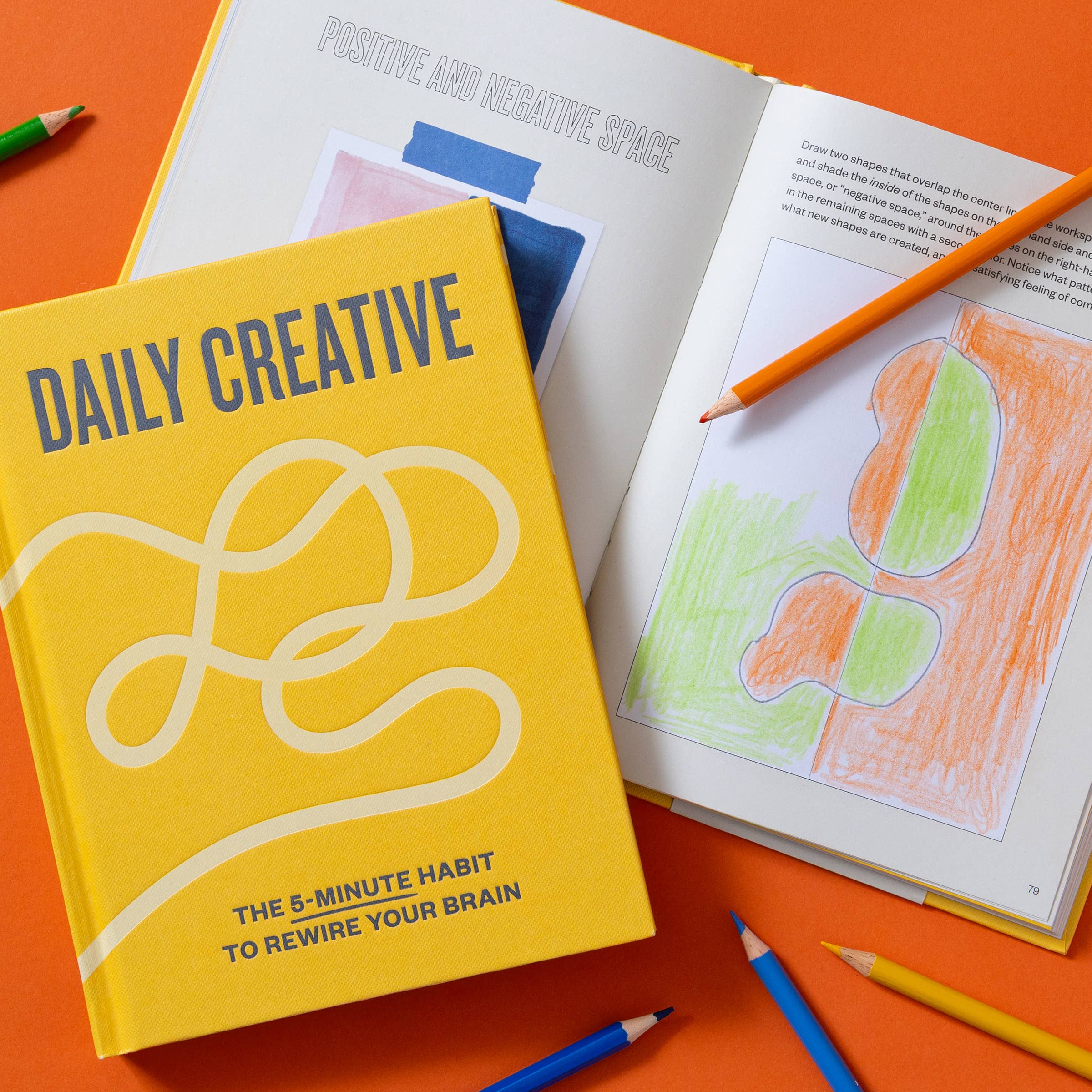 Daily Creative book with open artbook, colored pencils, and five-minute creative practices on table.