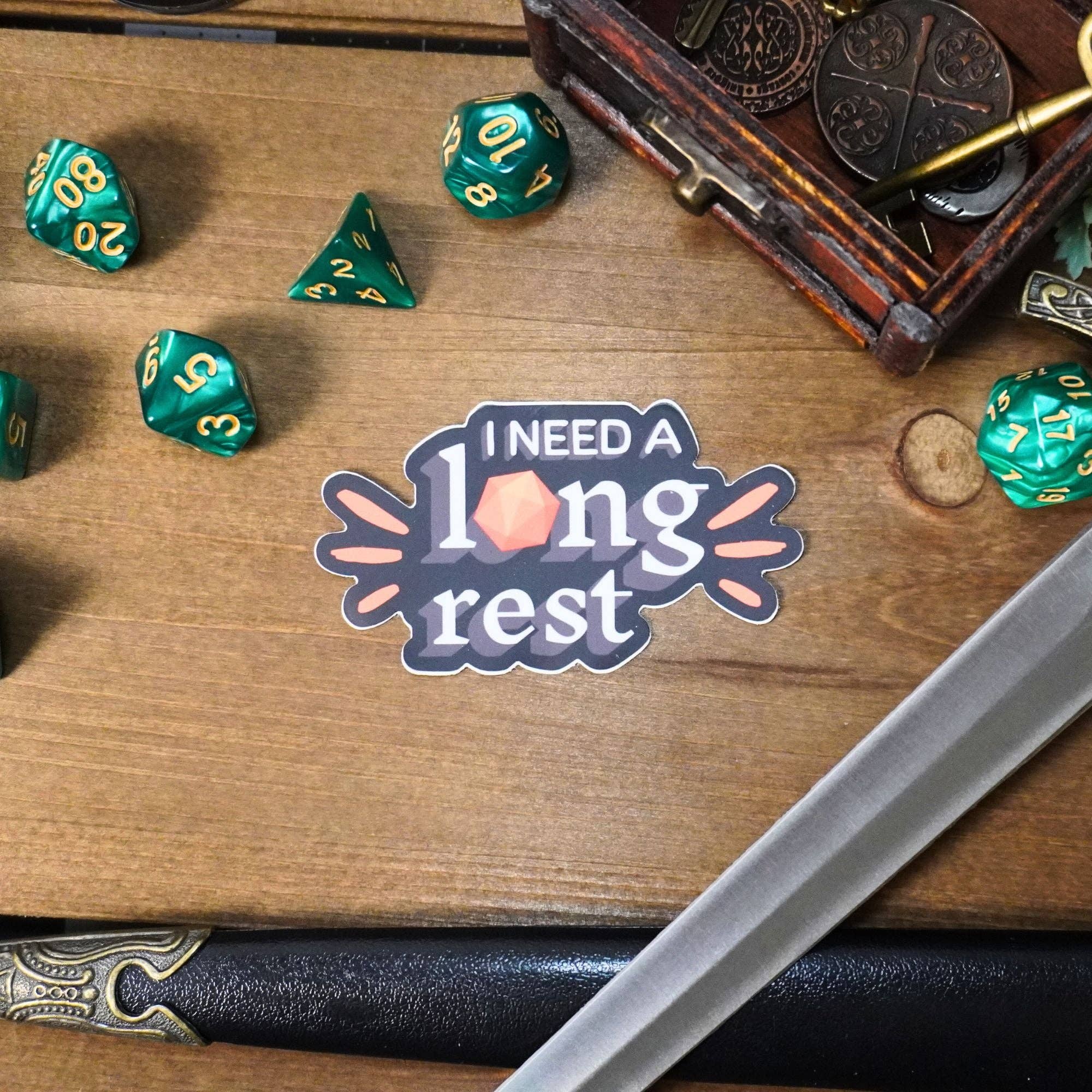 I Need a Long Rest sticker featuring dice, sword, coins, and pen for tabletop RPG enthusiasts.