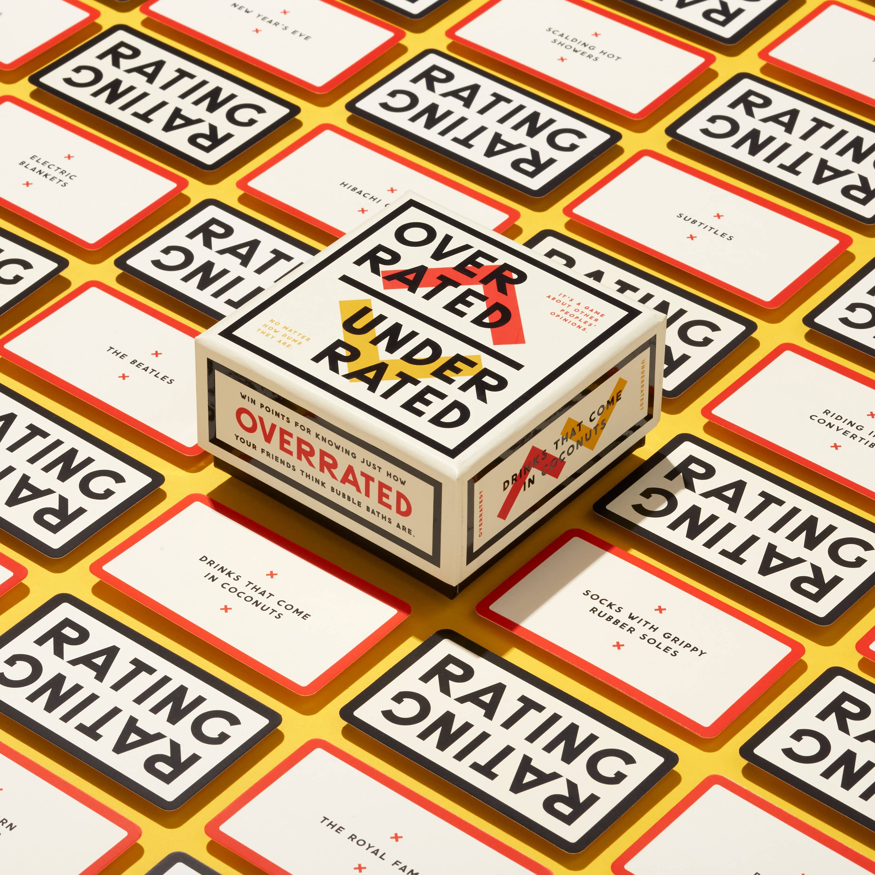 Brass Monkey Overrated / Underrated Social Game with matching cards displayed on a yellow surface.