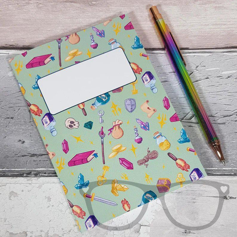 A6 Fantasy Adventure Notebook with dotted pages and blank label, shown with a rainbow pen.