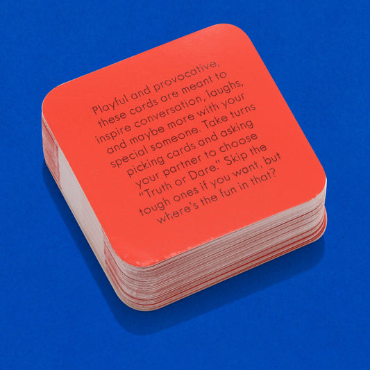 After Dinner Amusements: Truth or Dare for Couples card set stacked on a blue surface.
