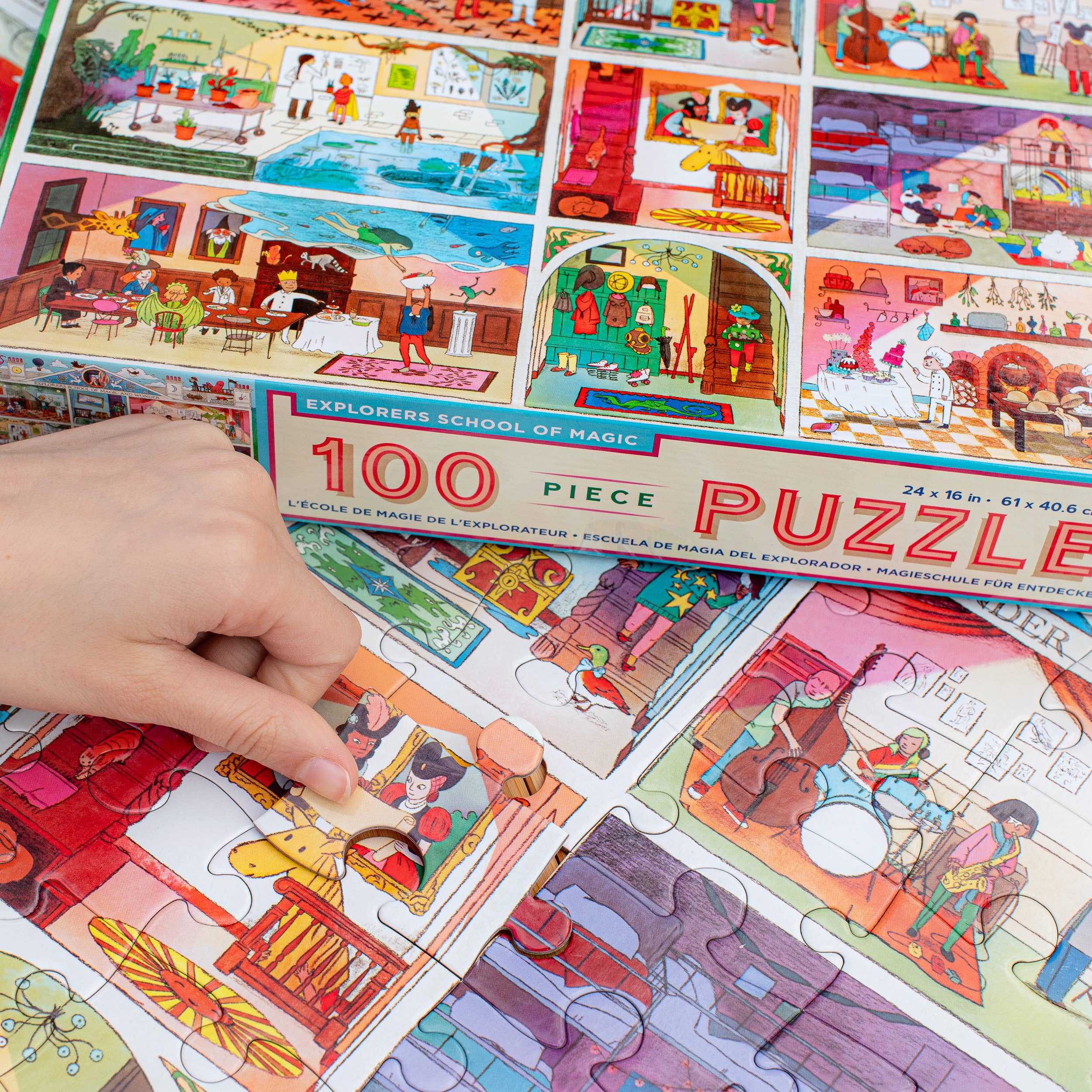 Explorers School of Magic 100 Piece Puzzle being assembled by a hand, featuring art by Jennifer Potter.