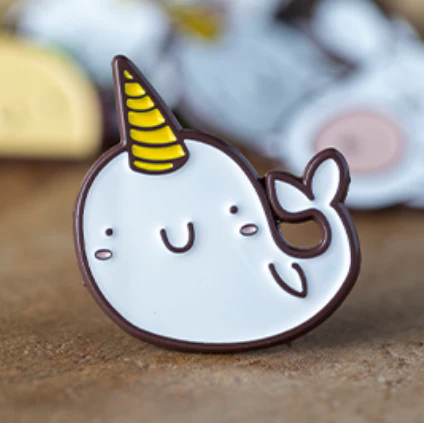 Narwhal Enamel Pin TCGCP with smiling face, yellow horn, and blushing cheeks.