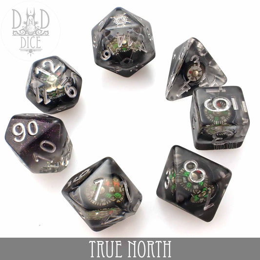 True North 7-piece black and clear resin dice set with working compasses in each die, arranged in a circle.