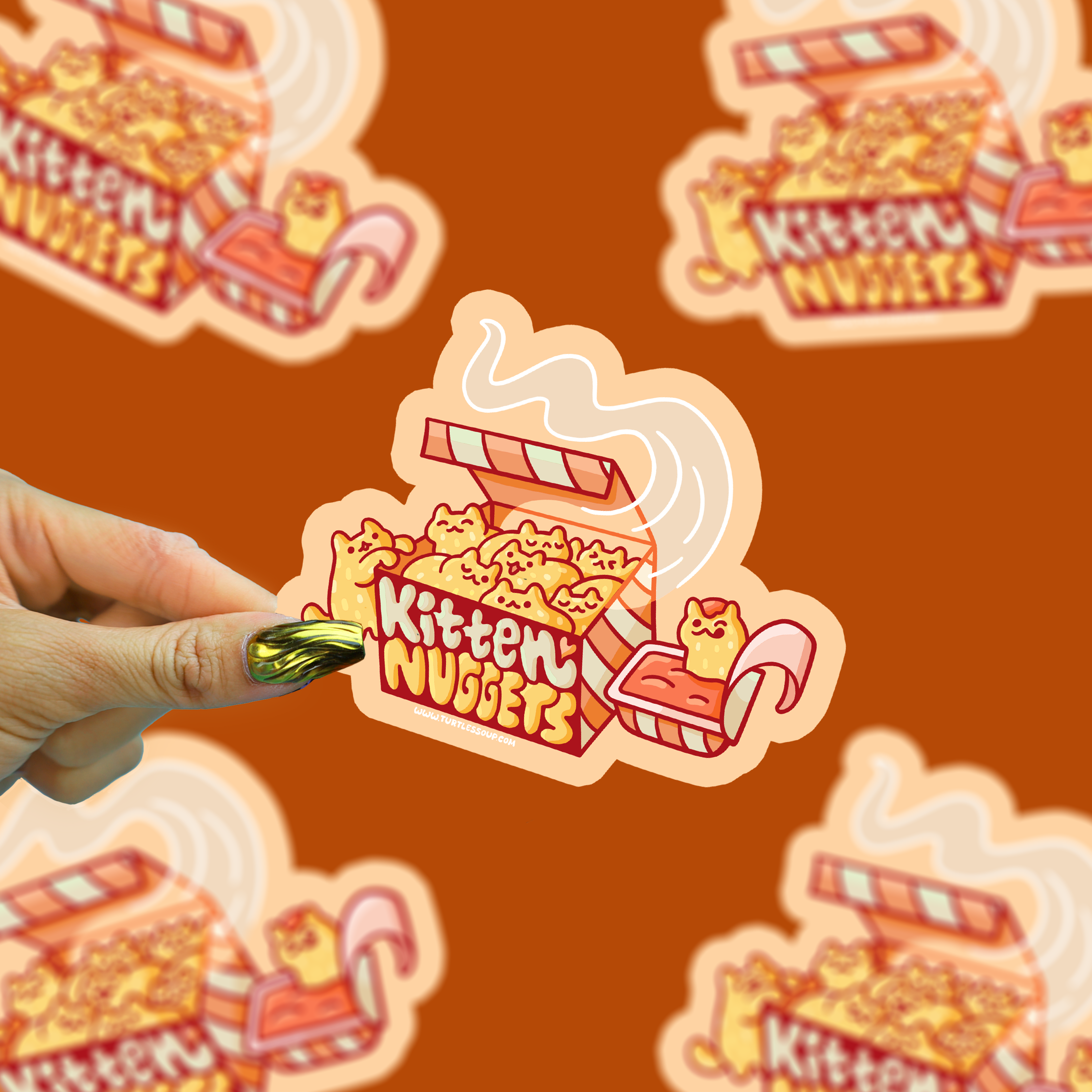 Kitten Nuggets Vinyl Sticker with cartoon kittens held in a hand.