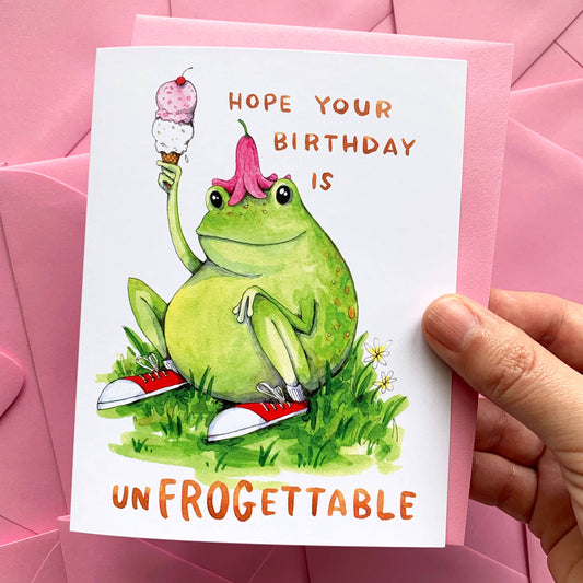Unfrogettable Frog Birthday Card with watercolor frog in sneakers holding ice cream, shown held in a hand.