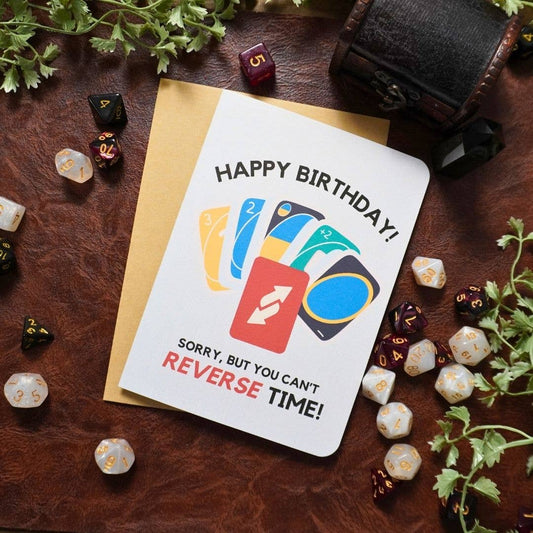 UNO-themed birthday card featuring dice, plants, and Sorry, but you can’t REVERSE TIME text. 5x7 inches.