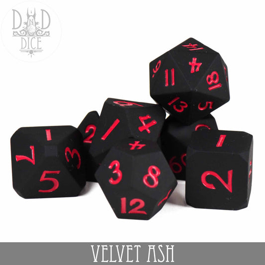Set of seven black Velvet Ash silicone tabletop gaming dice with red numbers.