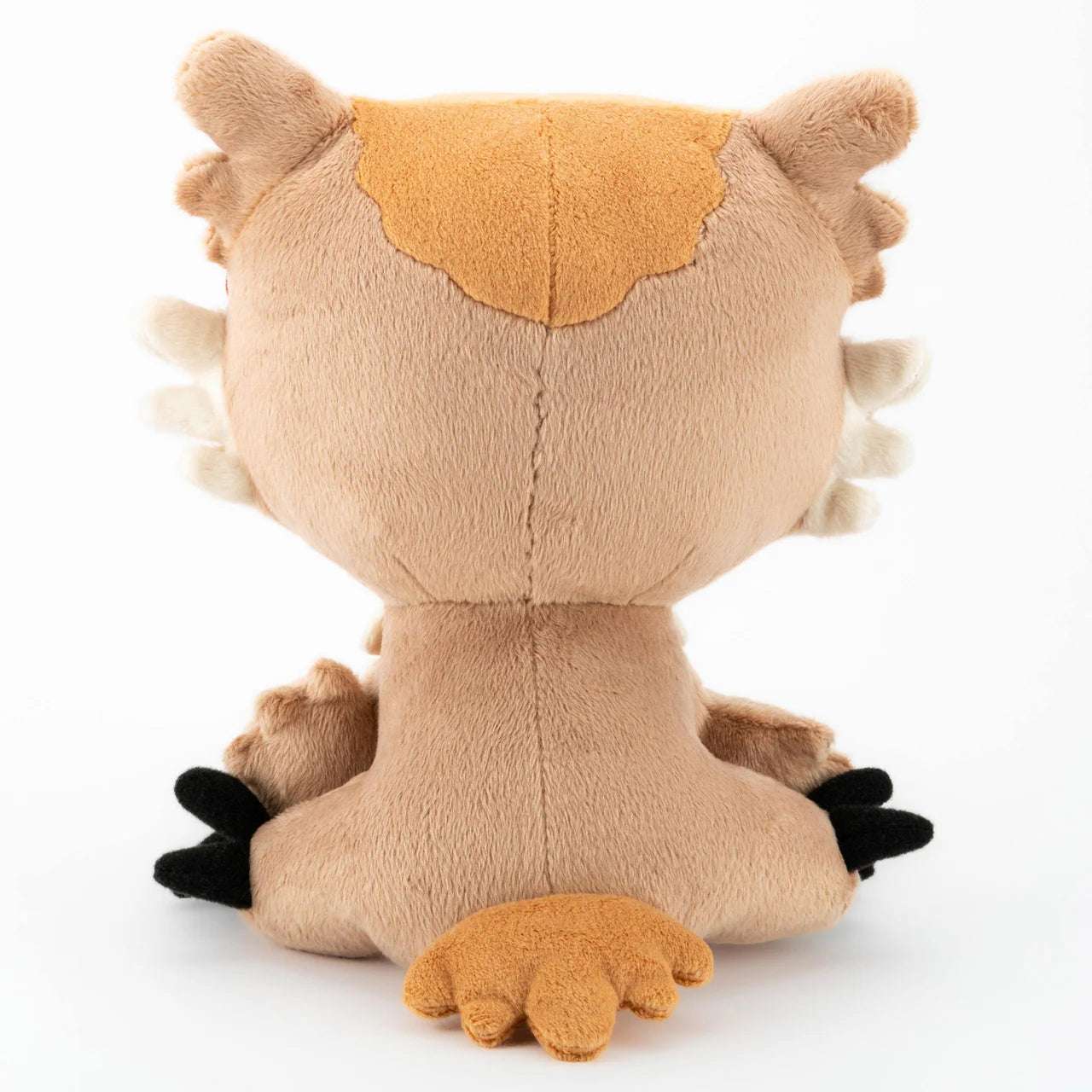 Owlbear Dawn 8-inch plushie with a tail and dark paws, seen from the back while sitting.