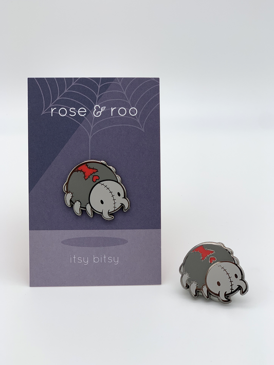 Two gray Itsy Bitsy Enamel Pins with red details.