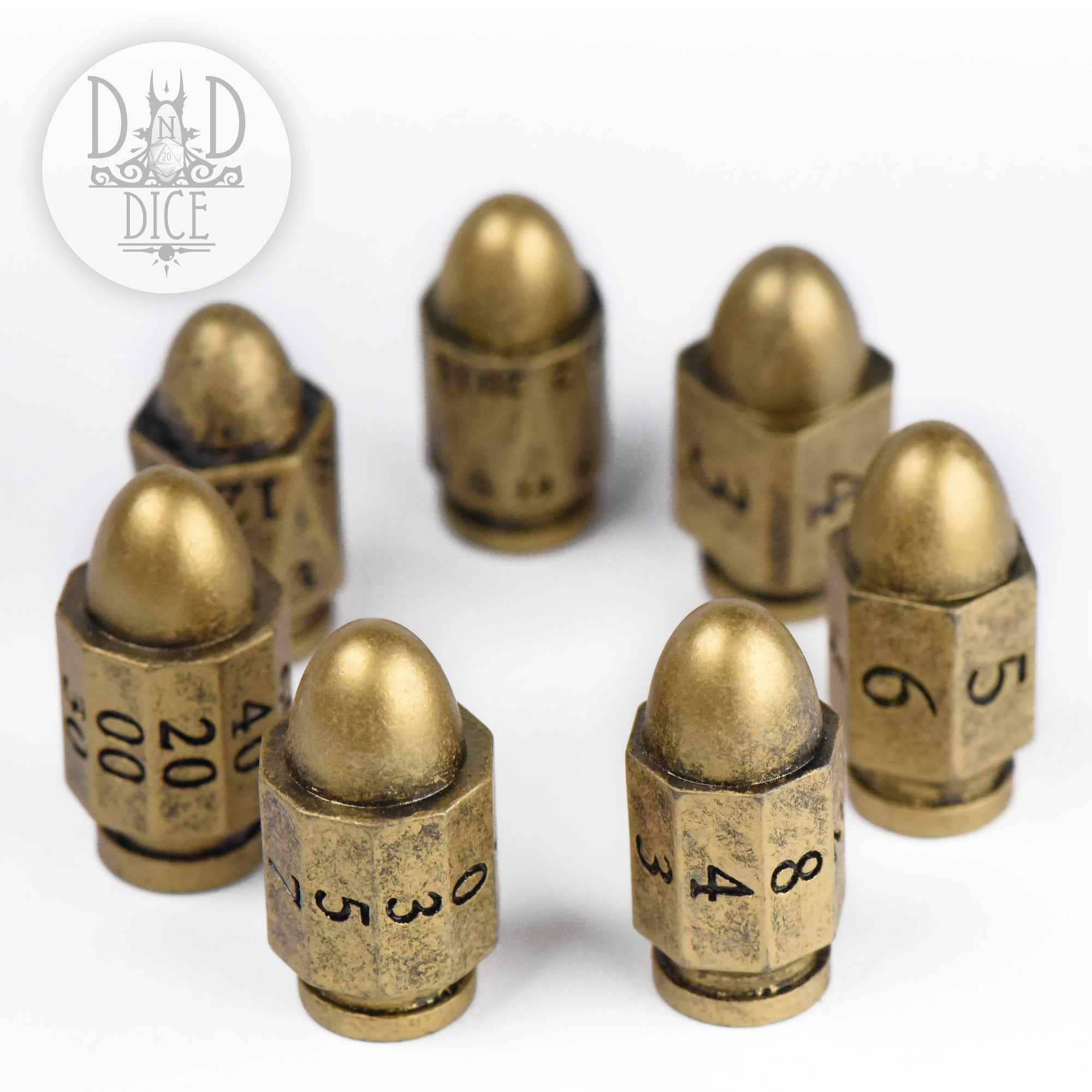 Seven bullet-shaped, brass-colored resin Top Brass dice; D&D dice logo shown in the corner.