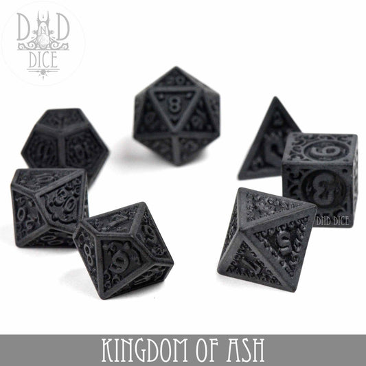 Kingdom of Ash black acrylic DND dice set with intricate carvings on a white surface.