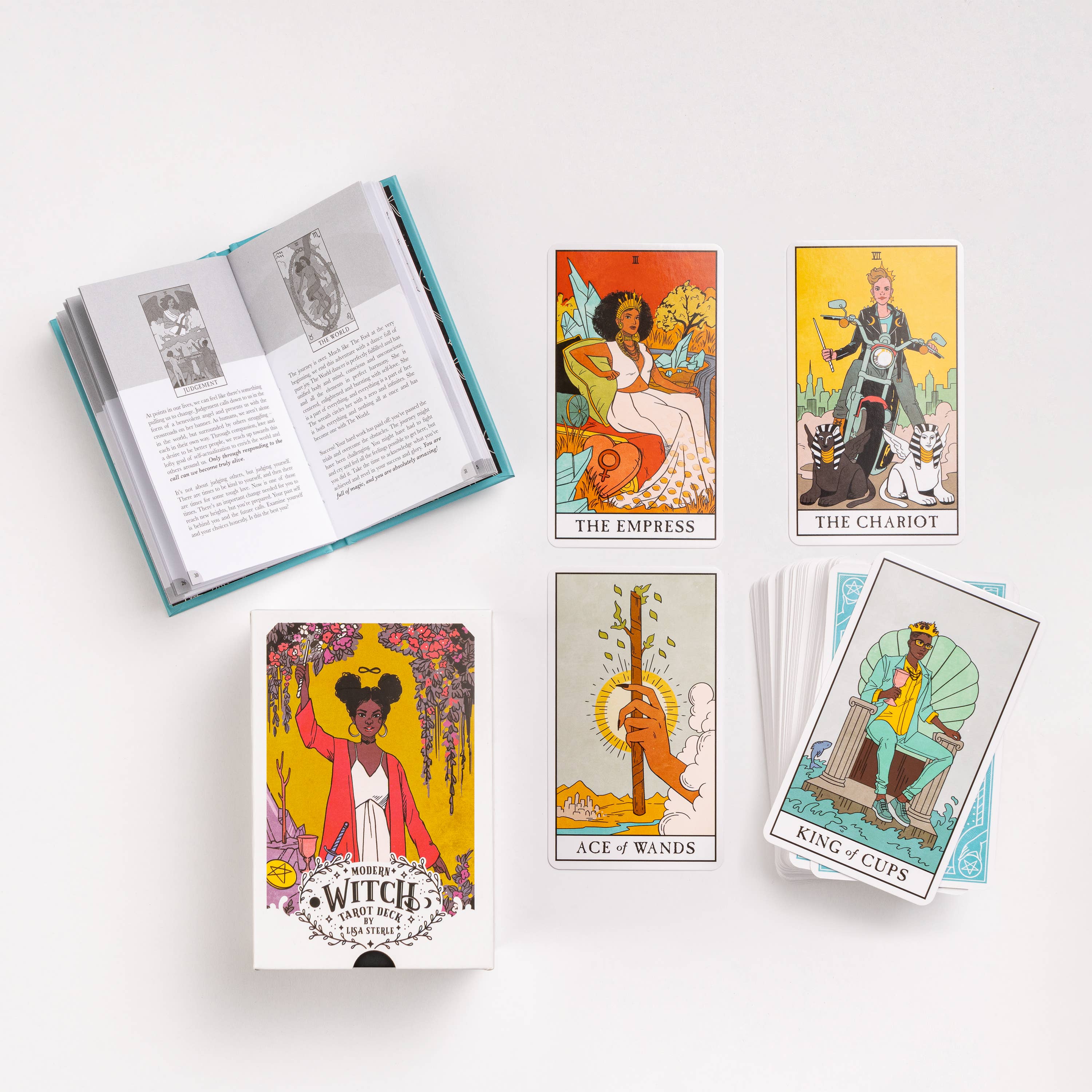 Modern Witch Tarot Deck set with an open guidebook and tarot cards, including The Empress and The Chariot.