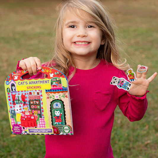 Cats Apartment Stickers displayed on girls fingers outdoors.