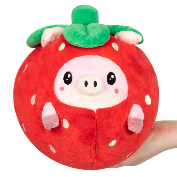 Undercover Pig in Strawberry Squishable, a pig toy dressed as a strawberry with green leaves, held in a hand.