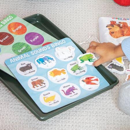 Child placing a card on ERIC CARLE: Brown Bear Animal Bingo board game.