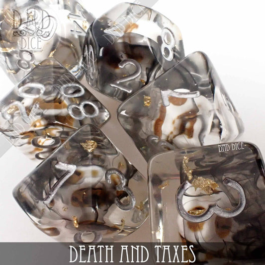 The Death and Taxes dice set: seven clear resin polyhedral dice with black, white, and gold swirls.