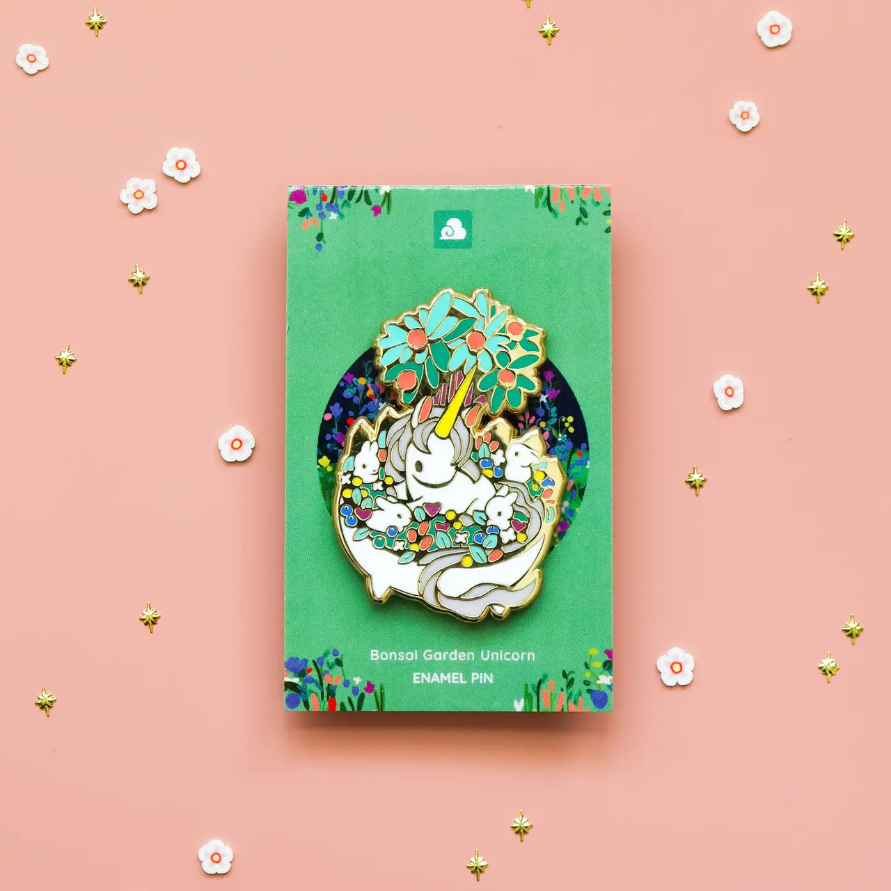 Bonsai Garden Unicorn enamel pin featuring a unicorn in a flower bonsai pot, displayed on green backing.