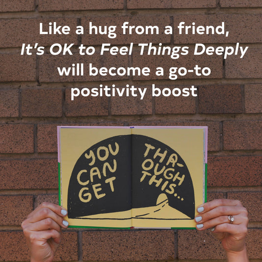Person holding open Its OK to Feel Things Deeply book with uplifting text visible above.