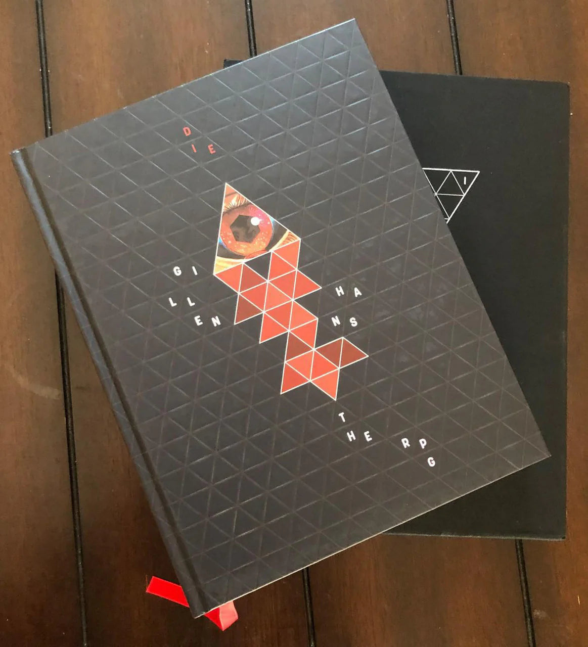 Die: The Role Playing Game (Deluxe) black book with red shapes and an eye on the cover.