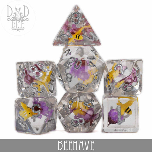 BEEhave 7-dice set in clear resin with embedded bees and flowers, arranged in a pyramid.