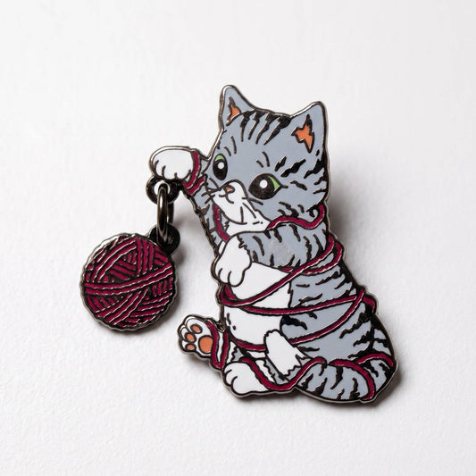 Gray tabby kitten pin in red yarn with black plating and a dangling red yarn ball charm.