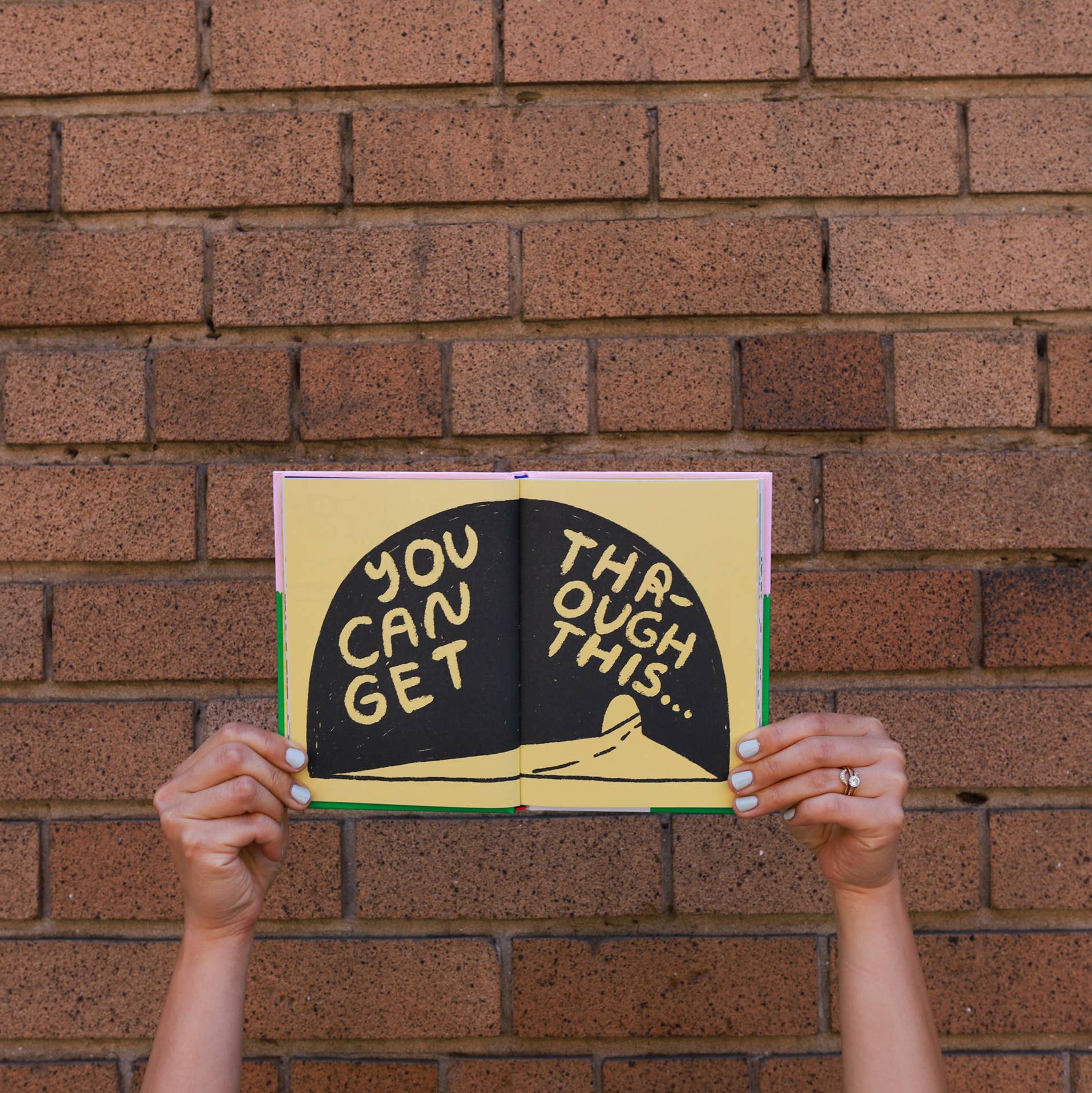 Hands hold the book *Its OK to Feel Things Deeply*.