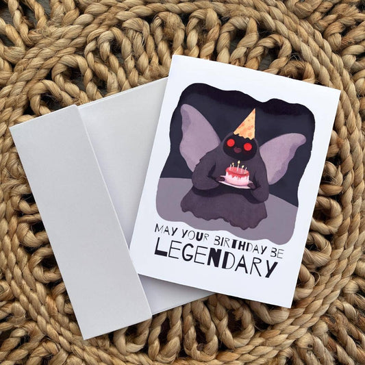 Mothman Cryptid Birthday Card featuring Mothman in a party hat with cake and the text May your birthday be legendary.