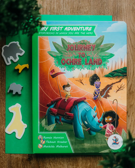 My First Adventure: Journey to Ochre Land book cover featuring a rhino, children, and a mask in a savanna setting.