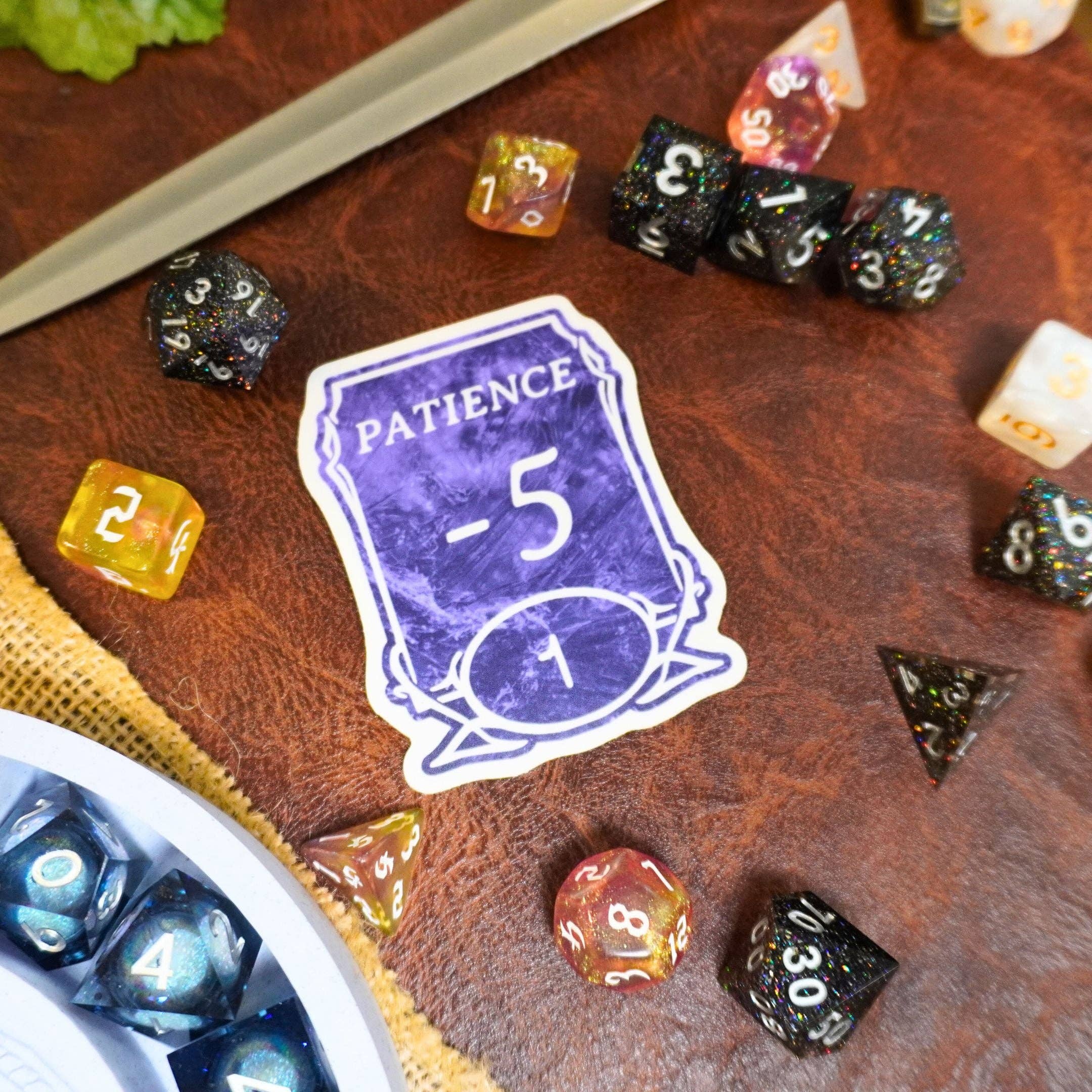 Patience -5 Sticker and colorful dice on a brown tabletop.