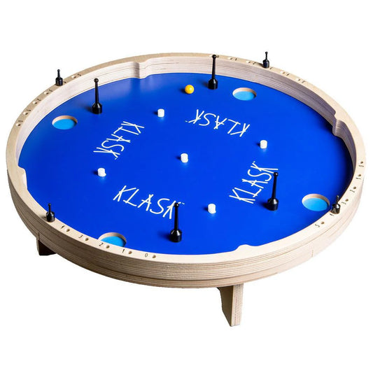 Round blue Klask 4 game board with holes, white obstacles, black handles, and KLASK text on top.