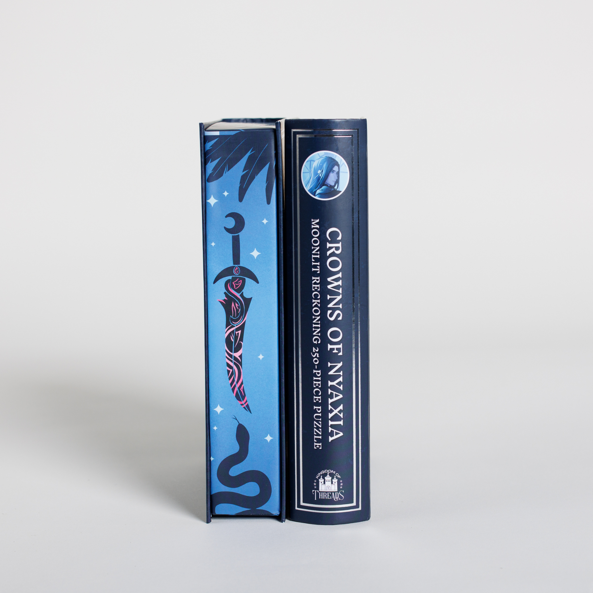 Moonlit Reckoning Keepsake Puzzle with celestial sword and snake motif next to a romantasy portrait puzzle.