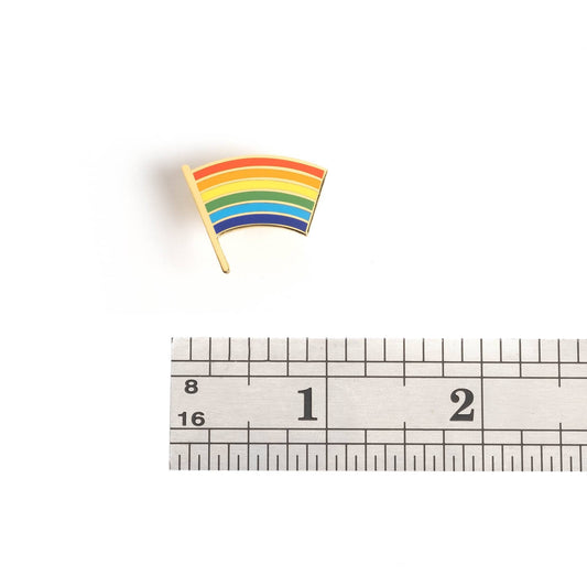 Pride Flag Pin next to a ruler showing 1 inch on a white background.