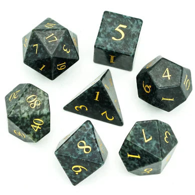 Seven Algal Gemstone RPG dice with gold engraving displayed on a white surface.