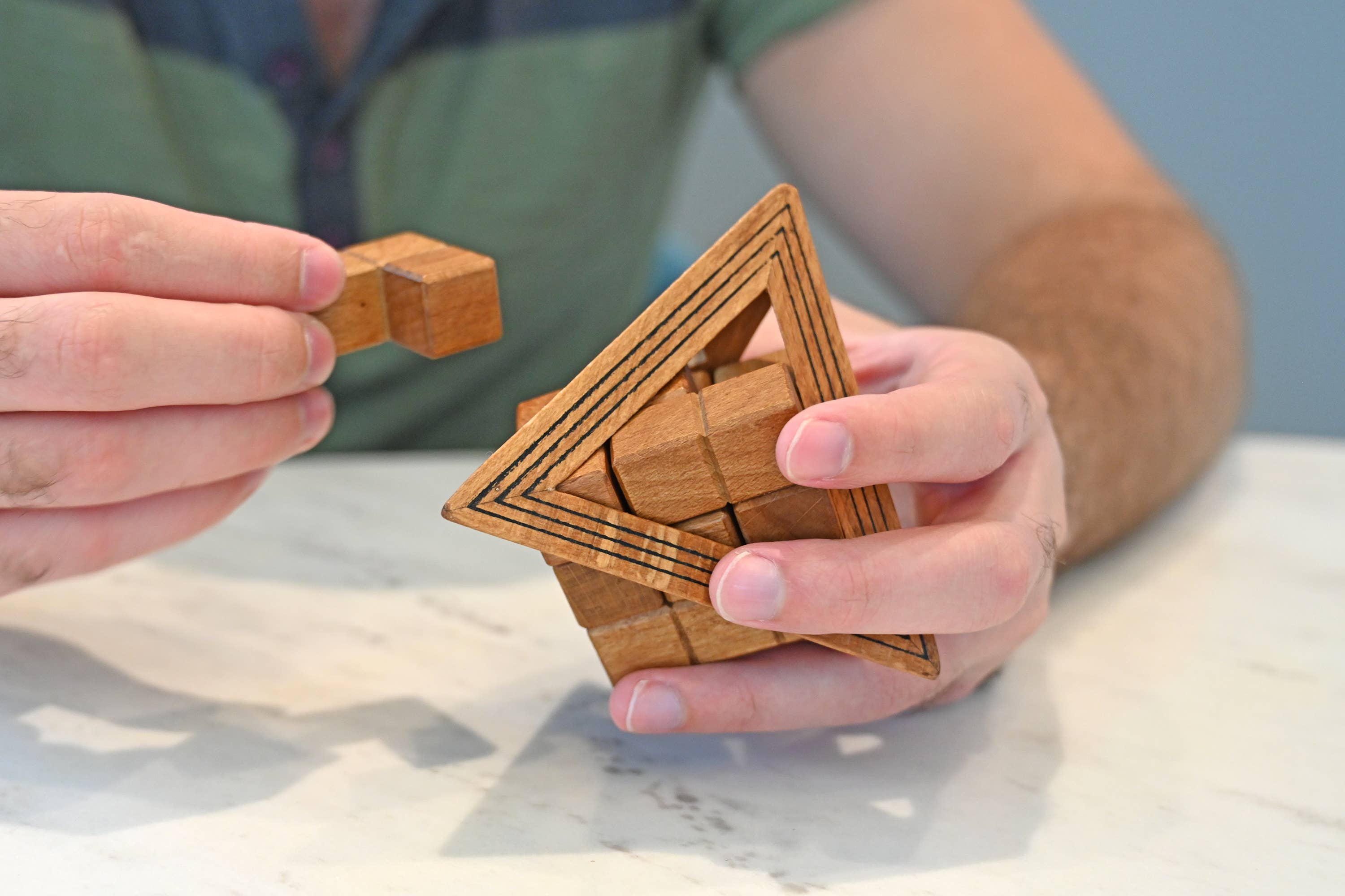 True Genius Egyptian Triglyph Puzzle pieces being held on a white table.