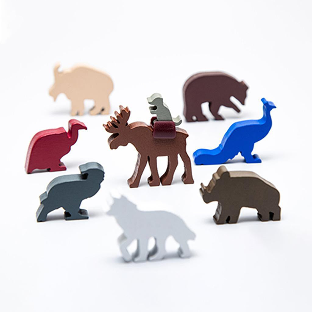 Everdell: Spirecrest Expansion wooden animal figures, including moose and penguin, on a white surface.