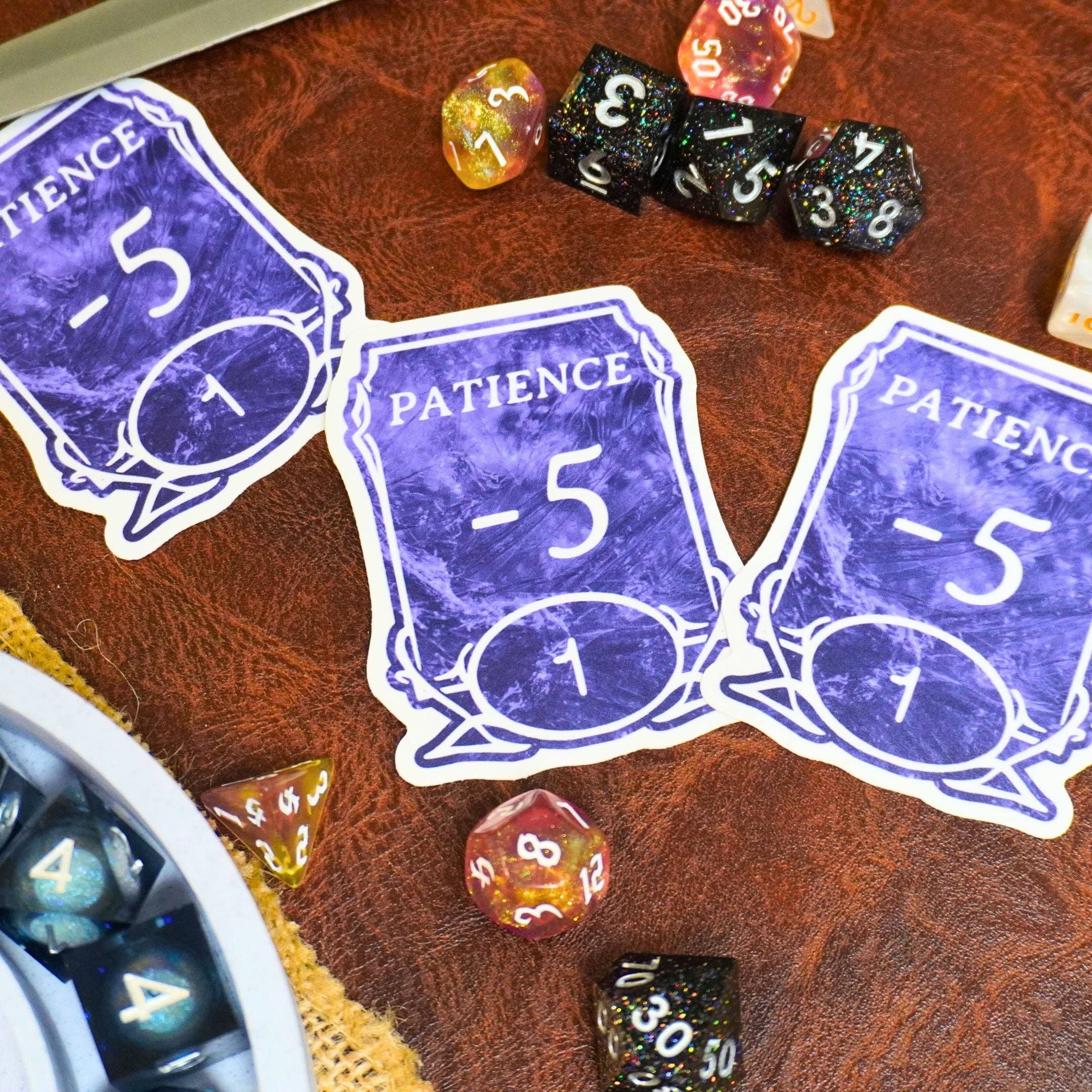 Three Patience -5 Stickers with colorful dice and a dice bowl on a table.