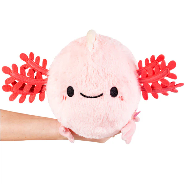 Mini Squishable Baby Axolotl, a round pink plush toy, held in a hand against a white background.